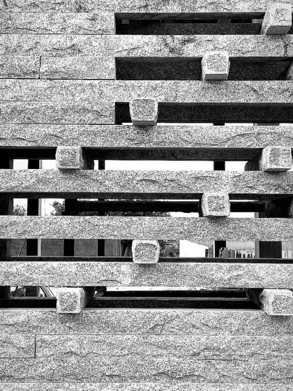 A black and white detail of the granite jaali at the Tiruppur house. The image emphasizes the texture, pattern, and the play of light and void.