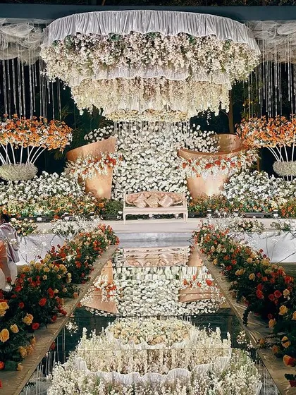 For a truly regal affair, I design spaces that exude luxury and grandeur. This stunning reception at the Taj West End features a magnificent floral stage and a mirrored aisle that reflects the entire spectacle, creating an atmosphere of pure opulence for you and your guests.