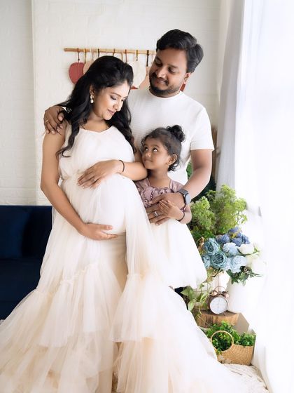 A sweet moment between mother and daughter, as the little one looks up at her mom's baby bump with curiosity and love.