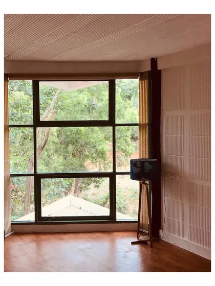 In this farmhouse retreat, a large window frames the lush greenery outside, turning nature into living art. My focus here was on biophilic design, creating a seamless connection between the interior and the exterior for a truly peaceful weekend home.