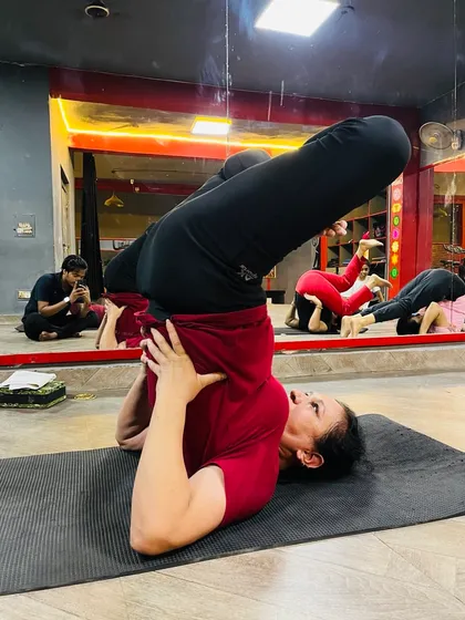 A student in Halasana (Plow Pose), a common posture in our classes for stretching the spine and shoulders.