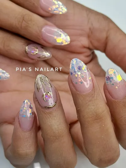 A modern bridal look with iridescent glitter flakes and a delicate gold chrome accent nail. It's perfect for the bride who wants something unique and chic.