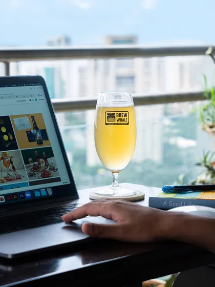 This image connects the product to a modern work-from-home lifestyle. The beer sits invitingly next to a laptop, suggesting it as the perfect reward after a productive day.