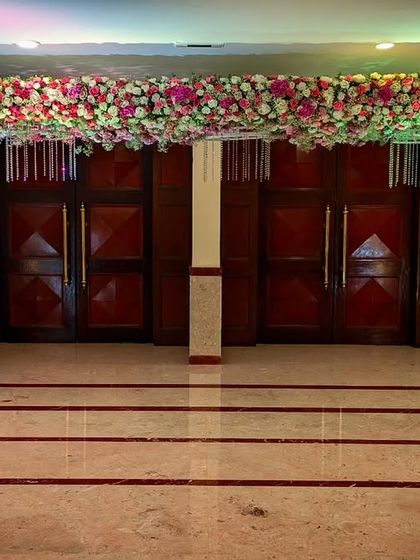 A wide view of the event space, showing how the floral arrangements and decor elements are used consistently throughout the venue to create a cohesive and immersive experience for guests.