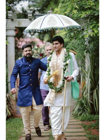 The groom during his Kasi Yatra, holding a traditional decorated umbrella.