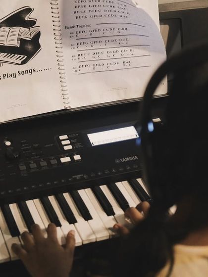 A student practices from a "Let's Play Songs" book. Our curriculum is structured to move from basic exercises to playing full songs.
