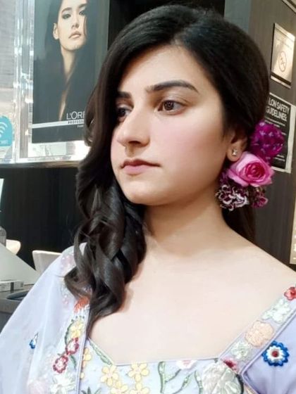 This client was ready for her Roka ceremony. The look features a soft, side-swept hairstyle adorned with fresh flowers and natural makeup that enhances her features.