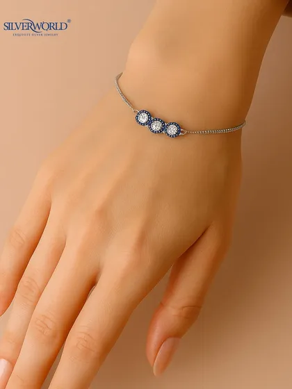 A modern evil eye bracelet design with three charms, where the central eye is clear zirconia and the flanking ones are blue. A stylish and protective accessory.