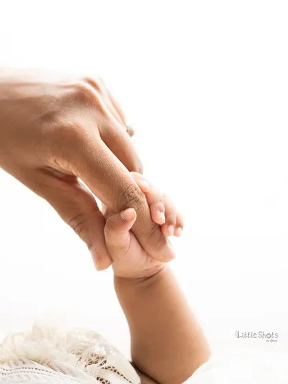 The simple, powerful image of a baby's hand holding a parent's finger. This shot beautifully represents the instant bond and connection within your new family.