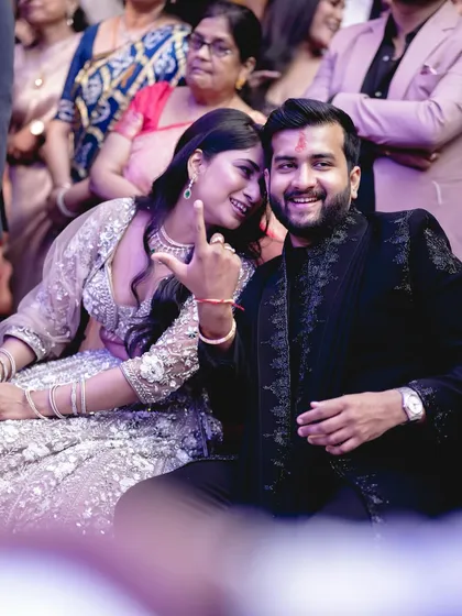 A fun, candid moment between the couple during their engagement ceremony, sharing a private joke.