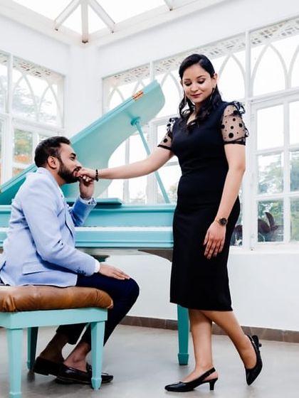 A romantic moment by the piano. The makeup is elegant and timeless, complementing the classic setting.