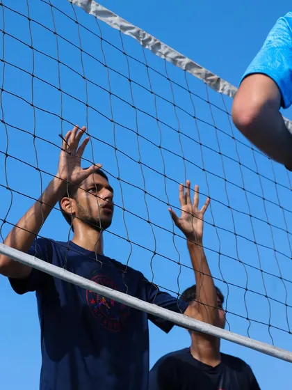 Learning to form a solid block at the net. This player is focused, with hands up and eyes on the opponent, ready to build a defensive wall.