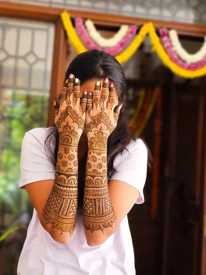 A playful pose showing off the full bridal henna.