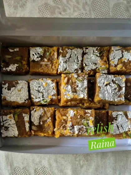 A box of my traditional Moong Daal Barfi, decorated with pure silver vark. I slow-roast the lentils in pure ghee for hours to achieve the perfect golden-brown color and rich, decadent flavor that melts in your mouth.
