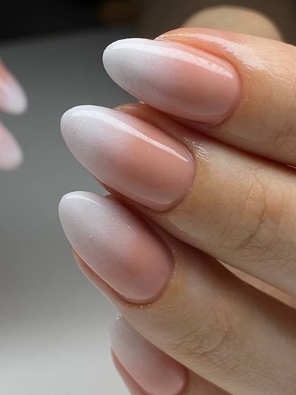 A beautiful ombré or 'baby boomer' manicure. The seamless gradient from a soft pink base to a milky white tip creates a sophisticated and modern look.