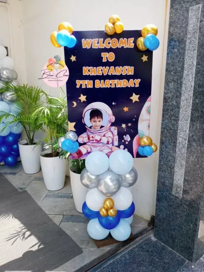 A personalized astronaut-themed welcome sign with balloon accents for a 7th birthday party.