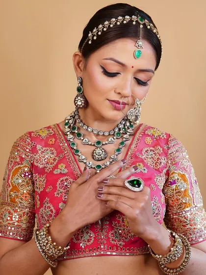 A close-up on the details. The makeup is kept elegant and understated to allow the magnificent, layered jewellery to take center stage.