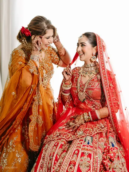 A heartwarming moment between the bride and her mother, sharing a laugh while getting ready.