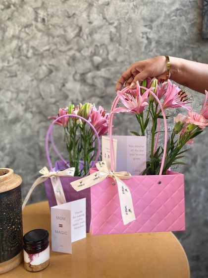 A close-up of our Mother's Day hampers. The combination of fresh lilies, a sweet treat, and a personal note is a simple yet powerful way to say "I love you".