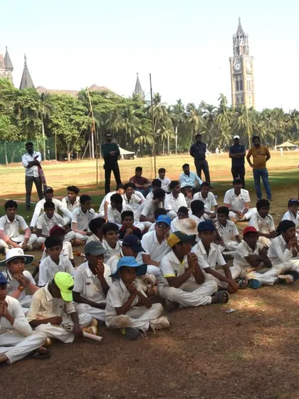 The U-12 players listening intently during the prize distribution ceremony, with the historic Mumbai High Court in the background.