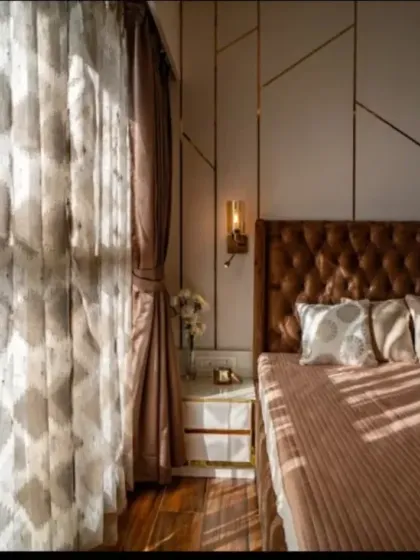 The play of natural light can transform a room. Here, sunlight streams through sheer curtains, highlighting the textures of the bedding and the geometric pattern on the accent wall, creating a serene and peaceful morning ambiance.