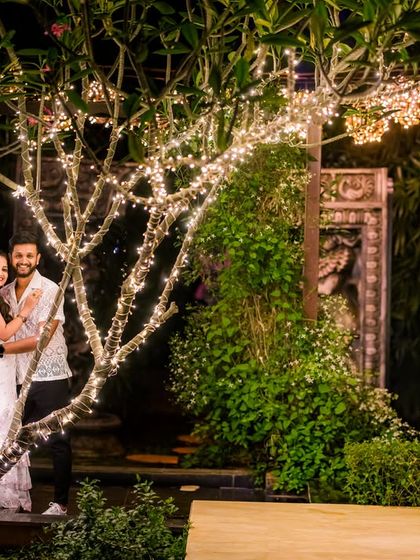 A wide shot of the garden at night, showing the beautiful ambiance created by the illuminated trees and swing.