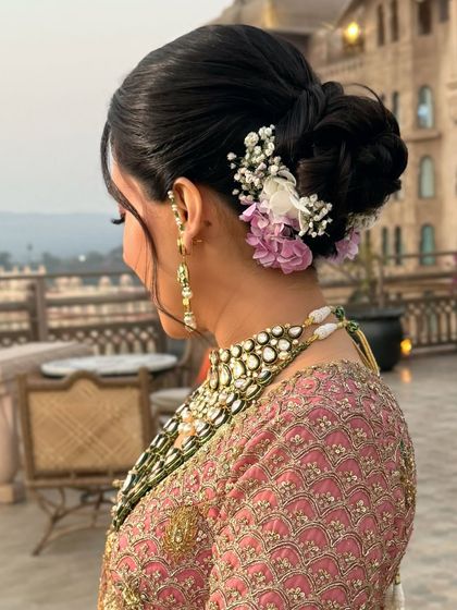 A side view of the sunset bridal updo, showing the soft tendrils and the placement of the flowers.