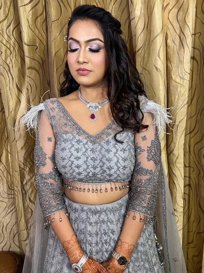 A full view of the soft glam engagement look. The feathered details on the grey lehenga are complemented by the subtle shimmer on her eyes and the radiant skin finish.