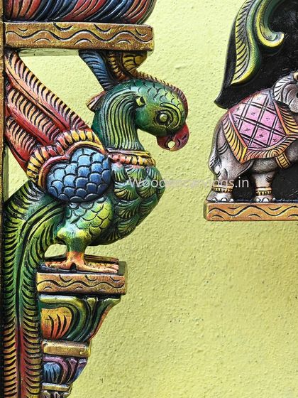 A close-up view where the parrot bracket and the elephant from the Gaja Ganesh panel are seen together, highlighting the consistent quality of our carving and painting.