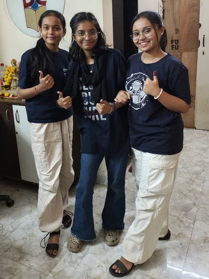 Three students showing off their coordinated outfits for Twinning Day, a fun event that builds camaraderie.