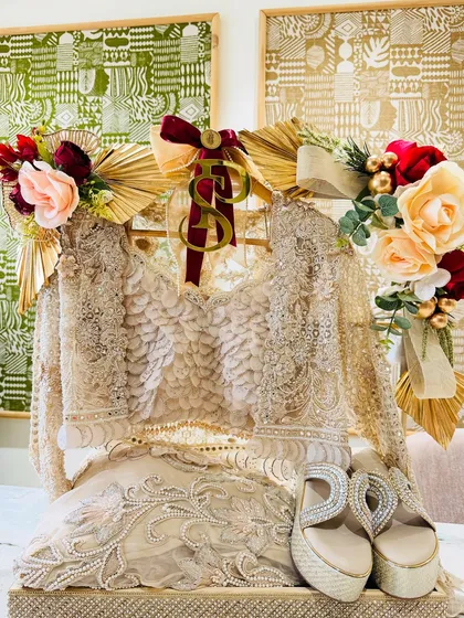 An ethereal ivory outfit paired with sparkling heels. The arrangement is accented with gold fans and soft florals for a touch of romantic glamour.