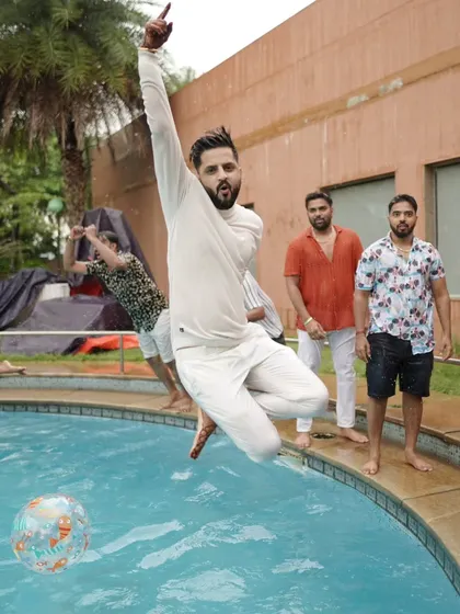 The groom takes a celebratory leap into the pool during a pre-wedding party. I make sure to capture these high-energy, spontaneous moments.