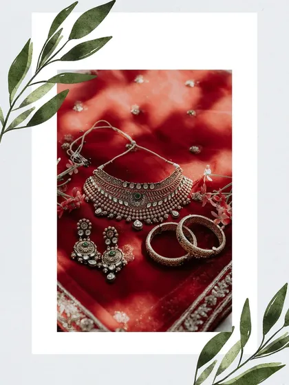 A flat-lay of the bridal jewelry. This artistic shot showcases the intricate design of the necklace, earrings, and bangles against the rich red of the bride's dupatta.