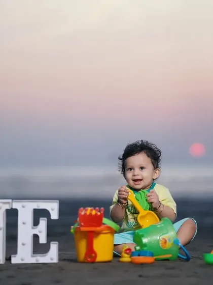 A happy first birthday shoot on the beach at sunset. Using 'ONE' block letters and colorful toys, I create a playful and scenic memory of this important milestone.