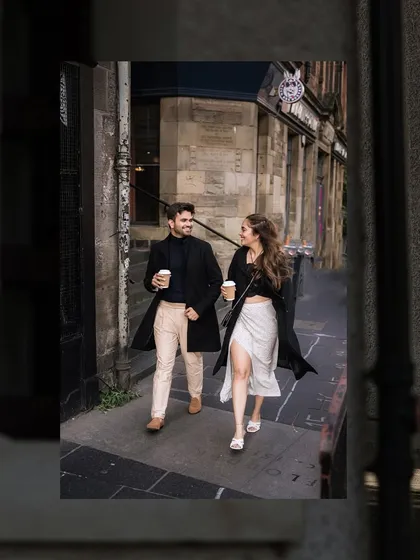 A candid shot of the couple walking and chatting with coffee in hand through the streets of Edinburgh. It captures a real, everyday moment of their life together.