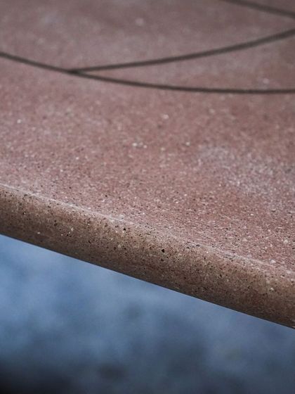 A detail of the smooth, rounded edge of the brass-inlaid terrazzo table, showing the quality of our finishing.
