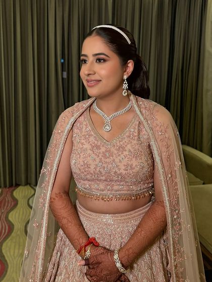 A smiling shot of Niyamat. Her makeup is elegant and sophisticated, perfect for a cocktail party.