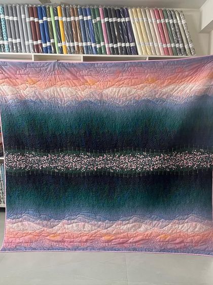 The full view of the beautiful scenery-print quilt, which looks like a painting.