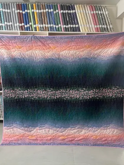 The full view of the beautiful scenery-print quilt, which looks like a painting.