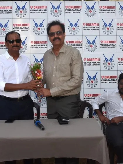 Presenting a bouquet to a guest of honor at the Dream11 Cup prize distribution.