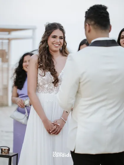 Another angle of the vow ceremony, capturing the bride's radiant smile as she listens to her groom.