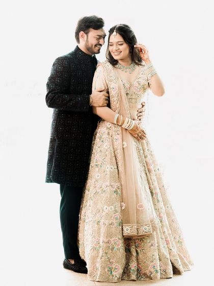 A classic and elegant high-key studio portrait. The all-white background makes the couple and their beautiful floral outfits pop, creating a fresh and timeless image.