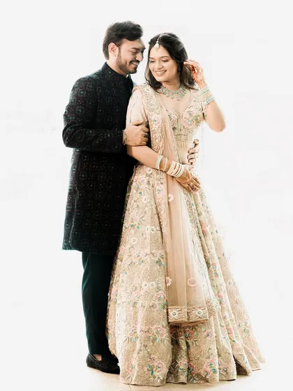 A classic and elegant high-key studio portrait. The all-white background makes the couple and their beautiful floral outfits pop, creating a fresh and timeless image.