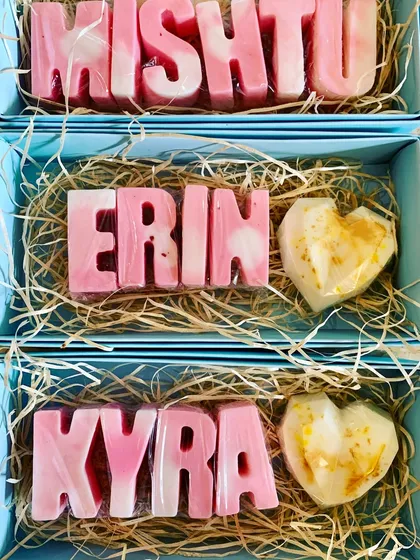 Elegant personalized name soaps in pastel pink and white, paired with a gold-dusted heart soap for a beautiful return gift.