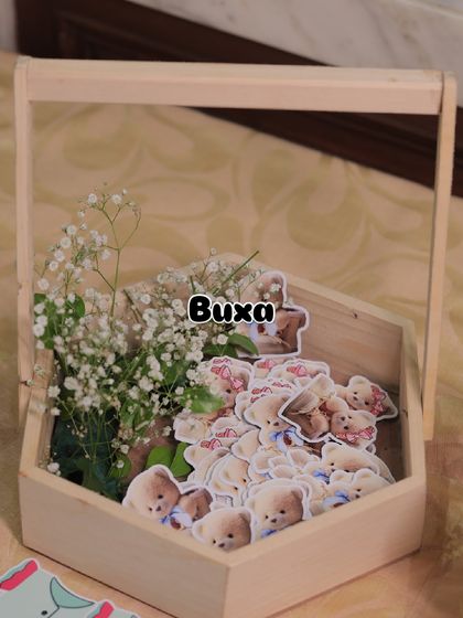 The first step in creating a beautiful baby shower centerpiece: a simple pinewood basket with fresh flowers and themed cutouts.