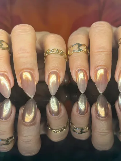 A full set of long, almond-shaped nails with a beautiful rose gold chrome finish.