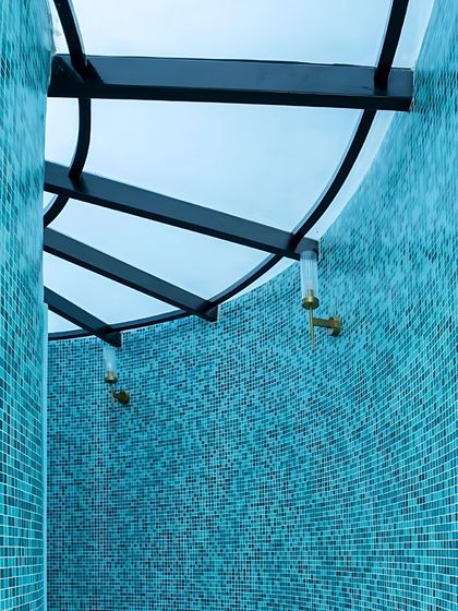 This angle shows the gentle curve of the bathroom wall, fully clad in mosaic tiles, creating a cocoon-like, immersive experience.