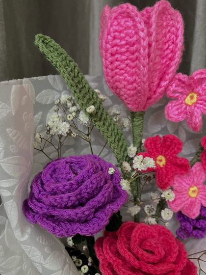 A detailed close-up of the textures in my crochet flowers. Notice the layered petals of the purple rose and the distinct shape of the pink tulip, all achieved through careful crochet techniques.