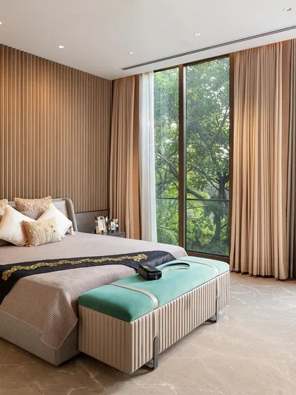 The master suite in our Punjabi Bagh project is a sanctuary designed for slow, luxe living. Expansive floor-to-ceiling windows invite the surrounding greenery indoors, while a fluted feature wall and understated materials create a serene, textural backdrop for rest and relaxation.