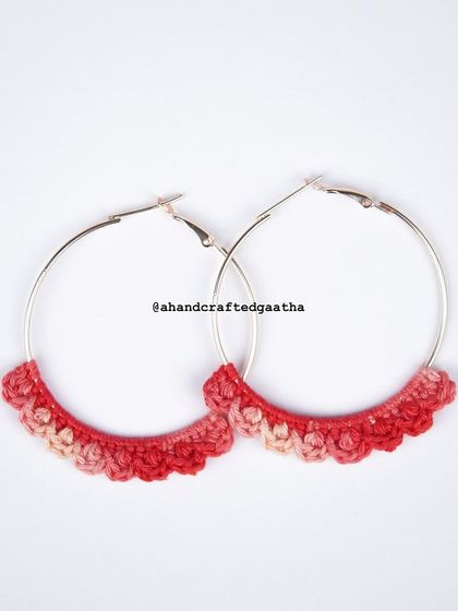 A clean product shot of the crimson 'Naazakat' hoops against a white background, highlighting the intricate crochet pattern and rich color.